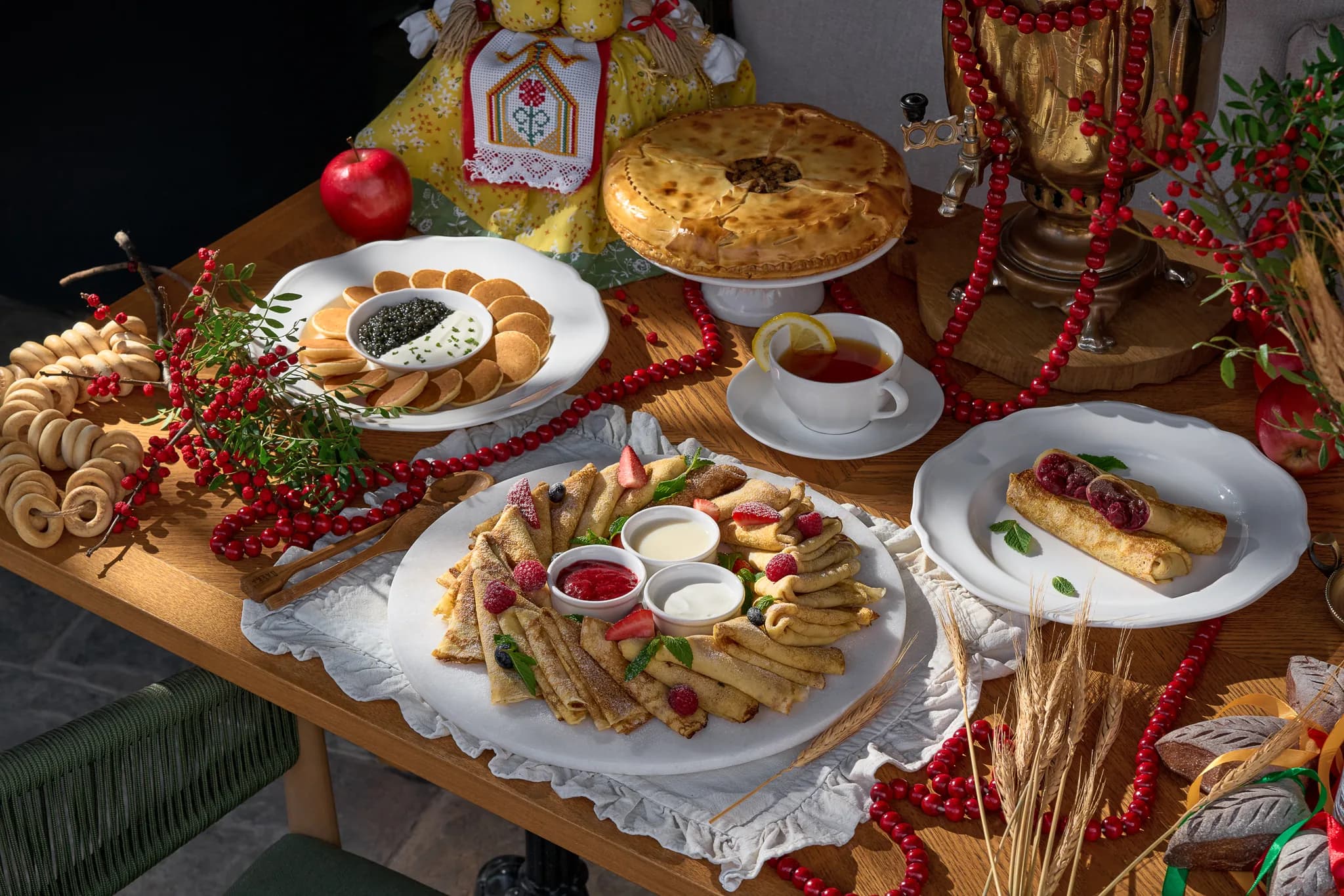 A Pechka spread of blini with berries and caviar, a pie, sushki and a samovar